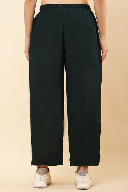 Person wearing black wide-leg pants on a beige background